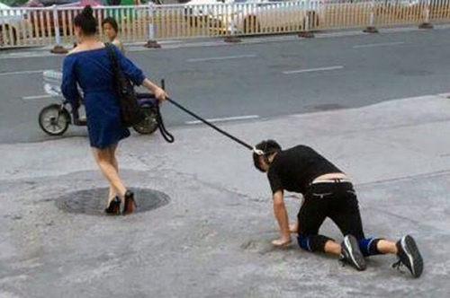 Người phụ nữ xích cổ chàng trai kéo đi trên phố Trung Quốc