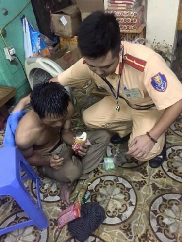 Cảnh sát giúp đỡ người nghèo bị ngất giữa đường mưa bão