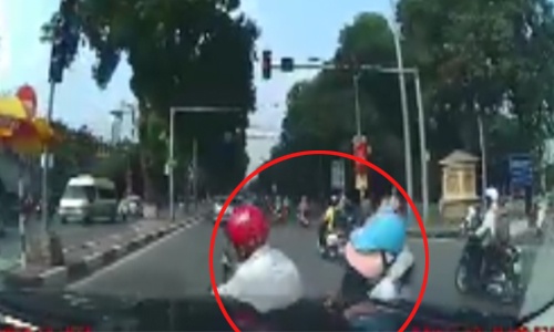 2 người đi xe máy nằm trước đầu ôtô vì sang đường ẩu