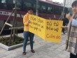 Mẹ Hàn cầm biển ngăn xe máy đi lên vỉa hè ở Hà Nội để bảo vệ con