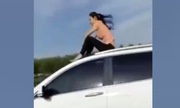 "Nữ siêu nhân" ngồi trên nóc ôtô đang chạy
