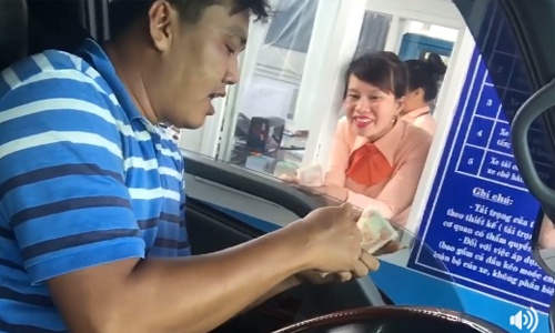 Nhân viên trạm thu phí Cai Lậy tươi cười khi tài xế đưa bọc tiền lẻ
